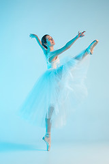 Image showing Young and incredibly beautiful ballerina is dancing in a blue studio