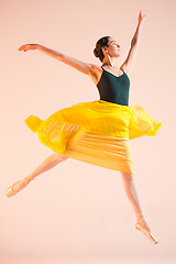 Image showing Young and incredibly beautiful ballerina is dancing at studio