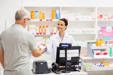 Image showing apothecary selling drug to senior man at pharmacy