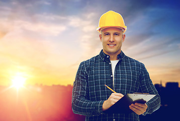 Image showing male builder in yellow hard hat with clipboard