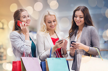 Image showing happy women with smartphones and shopping bags
