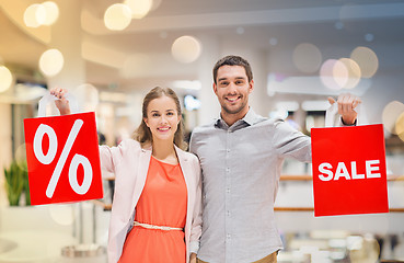 Image showing happy young couple with red shopping bags in mall