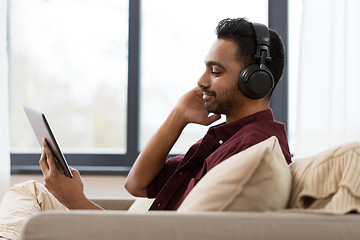 Image showing man in phones with tablet pc listening to music