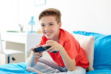 Image showing happy boy with gamepad playing video game at home