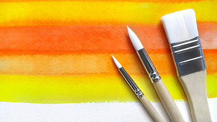 Image showing Bright watercolor background and paintbrushes