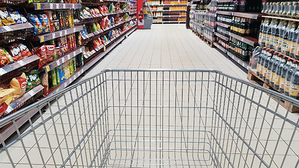 Image showing Shopping cart in supermarket aisle