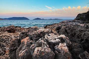 Image showing Sunset over rough volcanic rock coastline landscape