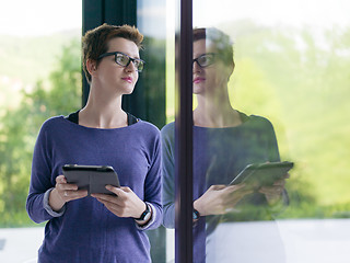 Image showing young women using tablet computer by the window