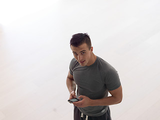 Image showing young man using a mobile phone  at home