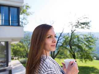 Image showing woman in a bathrobe enjoying morning coffee