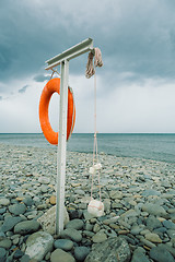 Image showing orange lifebuoy on the sea coast