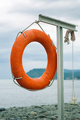 Image showing orange lifebuoy on the sea coast