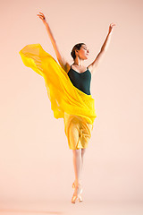 Image showing Young and incredibly beautiful ballerina is dancing at studio