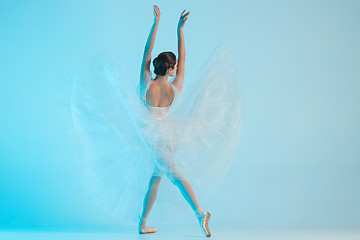 Image showing Young and incredibly beautiful ballerina is dancing in a blue studio