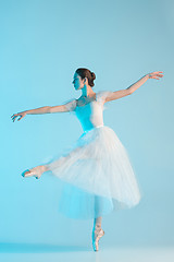 Image showing Young and incredibly beautiful ballerina is dancing in a blue studio