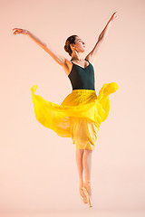 Image showing Young and incredibly beautiful ballerina is dancing at studio