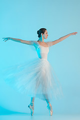 Image showing Young and incredibly beautiful ballerina is dancing in a blue studio