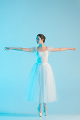 Image showing Young and incredibly beautiful ballerina is dancing in a blue studio