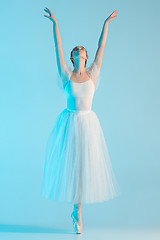 Image showing Young and incredibly beautiful ballerina is dancing in a blue studio