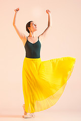 Image showing Young and incredibly beautiful ballerina is dancing at studio