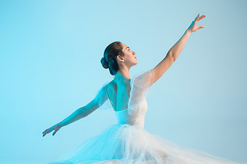 Image showing Young and incredibly beautiful ballerina is dancing in a blue studio