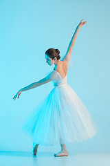 Image showing Young and incredibly beautiful ballerina is dancing in a blue studio