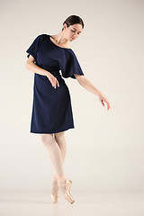 Image showing Young and incredibly beautiful ballerina is dancing in a blue studio