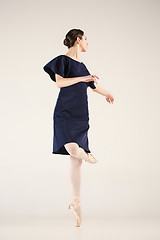 Image showing Young and incredibly beautiful ballerina is dancing in a blue studio