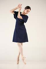 Image showing Young and incredibly beautiful ballerina is dancing in a blue studio