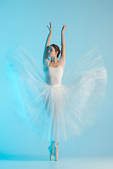 Image showing Young and incredibly beautiful ballerina is dancing in a blue studio