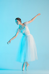 Image showing Young and incredibly beautiful ballerina is dancing in a blue studio