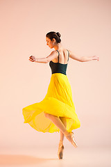 Image showing Young and incredibly beautiful ballerina is dancing at studio