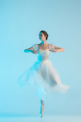 Image showing Young and incredibly beautiful ballerina is dancing in a blue studio