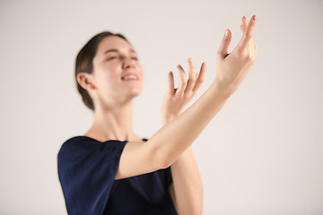 Image showing Young and incredibly beautiful ballerina is dancing at studio