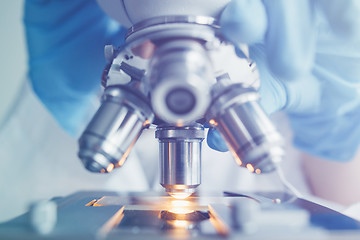 Image showing Close up of examining of test sample under the microscope