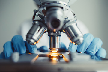 Image showing Close up of examining of test sample under the microscope