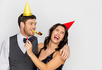 Image showing happy couple with party blowers having fun