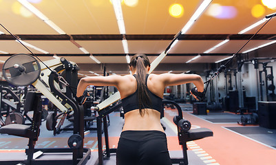 Image showing woman flexing muscles on cable machine in gym