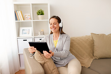 Image showing happy woman with tablet pc and headphones at home