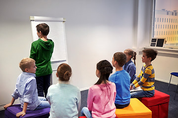 Image showing student boy with marker writing on flip board