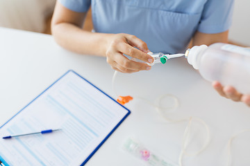 Image showing close up of nurse preparing drop counter