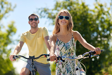 Image showing happy young couple riding bicycles in summer