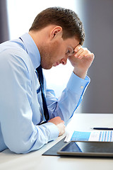 Image showing stressed businessman with papers at office