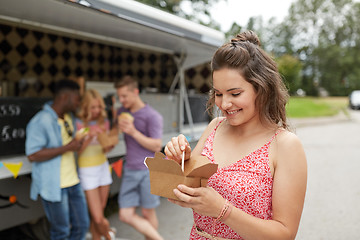 Image showing happy woman with wok and friends at food truck