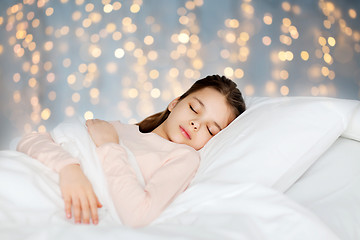 Image showing girl sleeping in bed over holidays lights