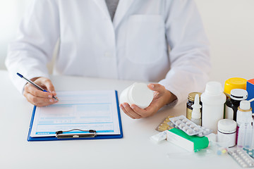 Image showing doctor with medicines and clipboard at hospital