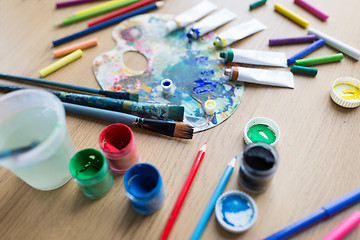 Image showing color palette, brushes and paint tubes on table