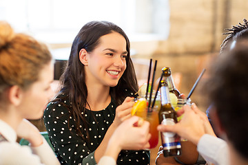 Image showing happy friends clinking drinks at bar
