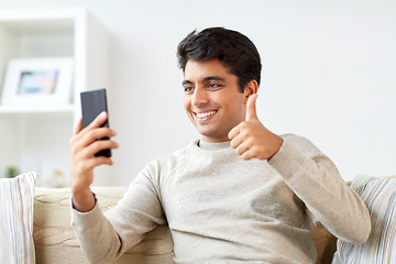 Image showing happy man having video call on smartphone at home