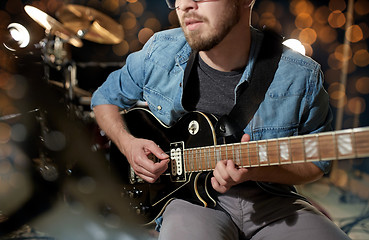 Image showing close up of musician playing guitar at studio